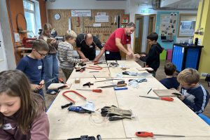 Kinder arbeiten gemeinsam mit Würth-Produktprofis beim KIKO-Workshop im Werkraum Melk an Holzprojekten