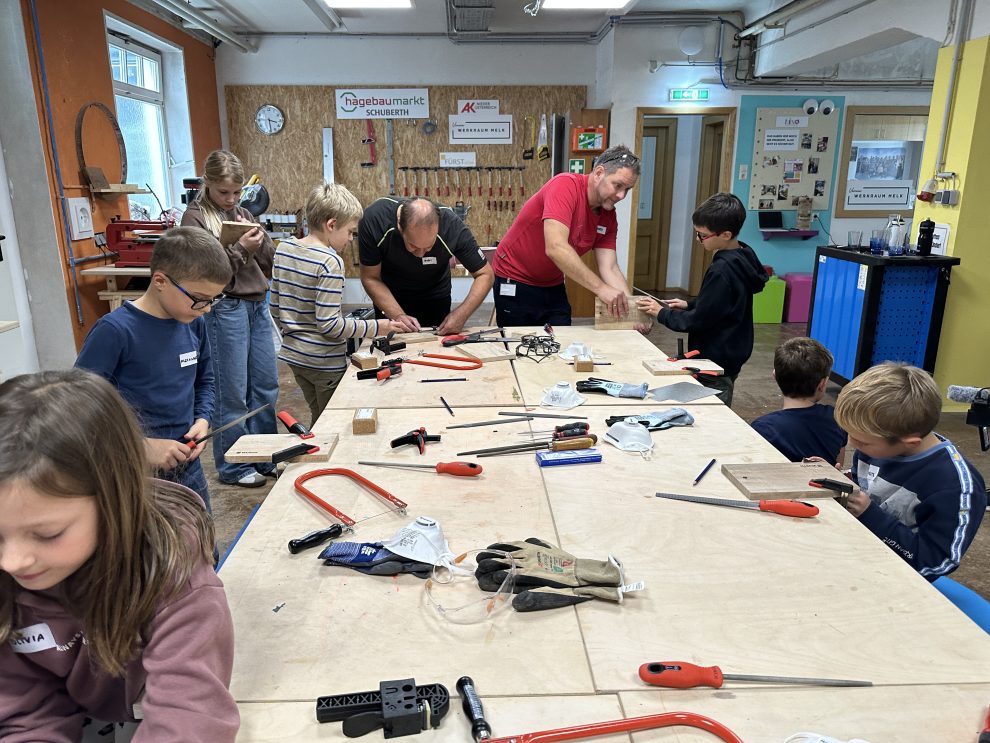 Kinder arbeiten gemeinsam mit Würth-Produktprofis beim KIKO-Workshop im Werkraum Melk an Holzprojekten